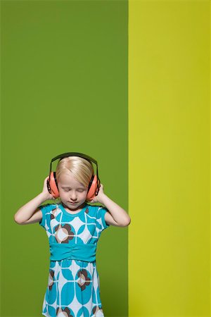 Little girl with eyes closed wearing protective headphones Fotografie stock - Premium Royalty-Free, Codice: 632-03193353