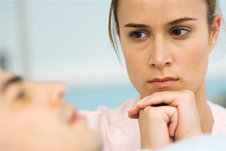 Woman watching sick patient, hands clasped under chin Stock Photo - Premium Royalty-Free, Code: 632-03193442