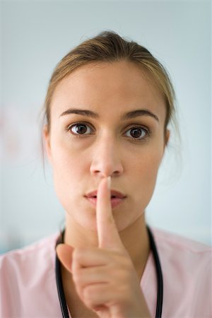 silence sign - Nurse holding finger to lips, portrait Stock Photo - Premium Royalty-Free, Code: 632-03193452