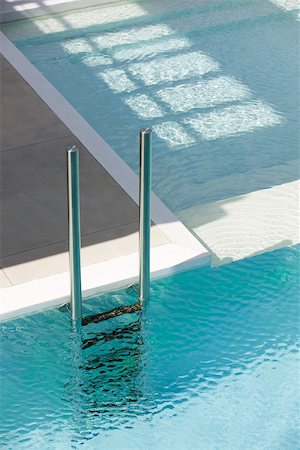 Swimming pool ladder at deep end separated from shallow pool by ledge Foto de stock - Sin royalties Premium, Código: 632-03193605