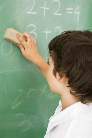 Boy erasing blackboard Stock Photo - Premium Royalty-Free, Code: 632-03193641