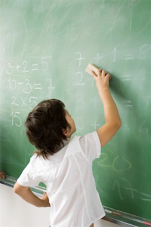 Boy erasing classroom blackboard, rear view Stock Photo - Premium Royalty-Free, Code: 632-03193656