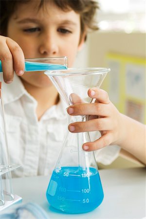 Boy transferring liquid from test tube to beaker using funnel Foto de stock - Sin royalties Premium, Código: 632-03193685