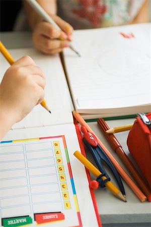 school supplies - Children writing in notebooks, school supplies nearby, cropped Stock Photo - Premium Royalty-Free, Code: 632-03193683