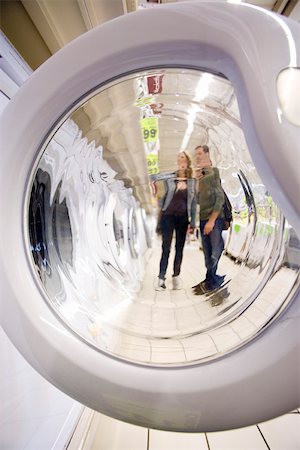 Shoppers seen through open washing machine door Stock Photo - Premium Royalty-Free, Code: 632-03193738