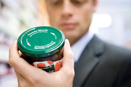 Homme lisant l'étiquette sur le pot de confiture Photographie de stock - Premium Libres de Droits, Code: 632-03193786