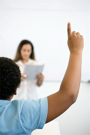 Elementary school student raising hand in class, rear view Stock Photo - Premium Royalty-Free, Code: 632-03403115