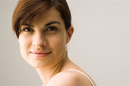 simsearch:695-03380090,k - Young woman smiling over shoulder, portrait Stock Photo - Premium Royalty-Free, Code: 632-03403365