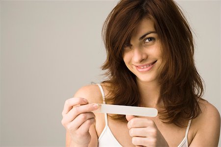 Young woman filing nails Stock Photo - Premium Royalty-Free, Code: 632-03403377