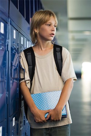 Junior high student leaning against locker in school corridor Stock Photo - Premium Royalty-Free, Code: 632-03424527
