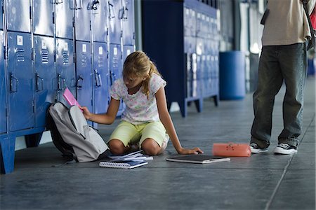 Junior high student picking up dropped school supplies, boy standing by watching Stock Photo - Premium Royalty-Free, Code: 632-03424528