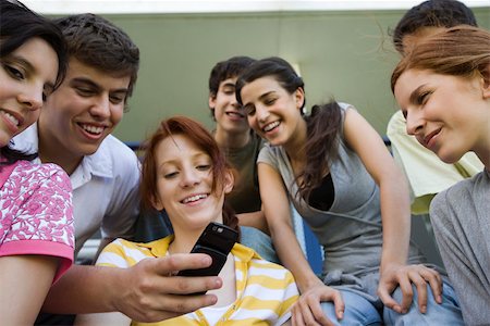 Teenagers looking at friend's photophone Stock Photo - Premium Royalty-Free, Code: 632-03424522