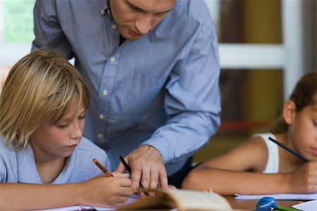 school children with teacher - Teacher helping elementary school student in class Stock Photo - Premium Royalty-Free, Code: 632-03424532