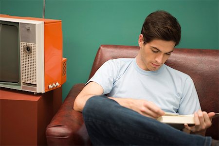 Young man relaxing with book Stock Photo - Premium Royalty-Free, Code: 632-03424634