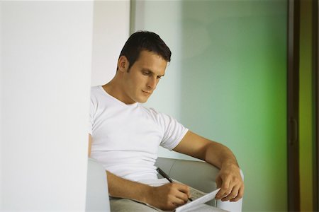 Man working crossword puzzle in newspaper Foto de stock - Sin royalties Premium, Código: 632-03424738