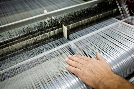 Weaving mill, machinist manually checking thread tension on a loom Foto de stock - Royalty Free Premium, Número: 632-03500474