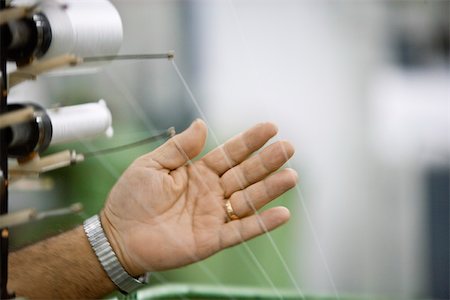 Machinist checking thread tension on loom in weaving mill Stock Photo - Premium Royalty-Free, Code: 632-03500476