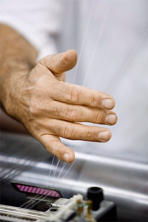 Machinist checking thread tension on loom in weaving mill Stock Photo - Premium Royalty-Free, Code: 632-03500477