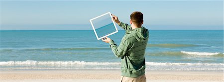 simsearch:632-03500786,k - Holding framed picture of ocean at angle against ocean in background Stock Photo - Premium Royalty-Free, Code: 632-03500759