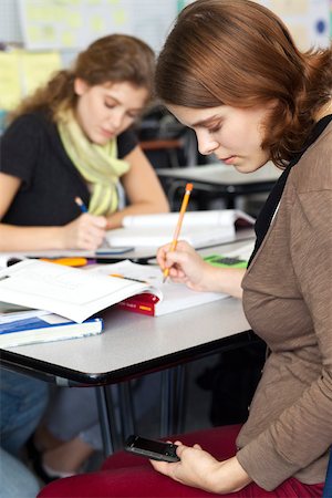 Young woman text messaging while in class Stock Photo - Premium Royalty-Free, Code: 632-03516554