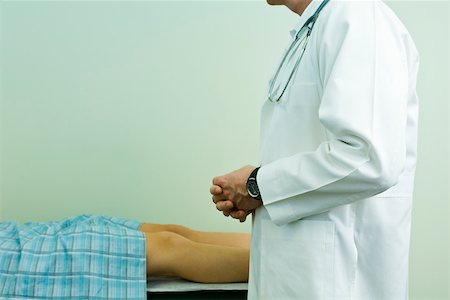 simsearch:632-03629633,k - Doctor speaking to patient lying on examination table Fotografie stock - Premium Royalty-Free, Codice: 632-03516743