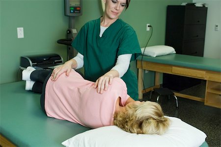 physiotherapist treating - Woman being treated by physical therapist Stock Photo - Premium Royalty-Free, Code: 632-03516809