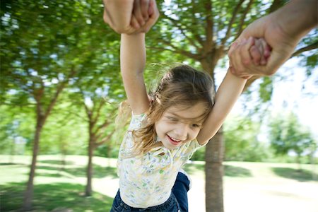 Little girl being swung through air by her arms Stock Photo - Premium Royalty-Free, Code: 632-03516967