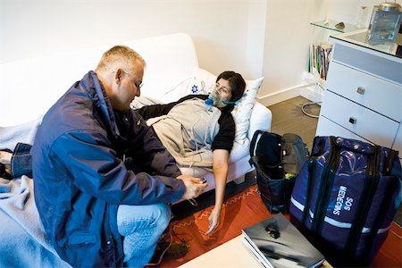 doctor patient services - Emergency on-call doctor administering oxygen to patient in home Foto de stock - Sin royalties Premium, Código: 632-03629684