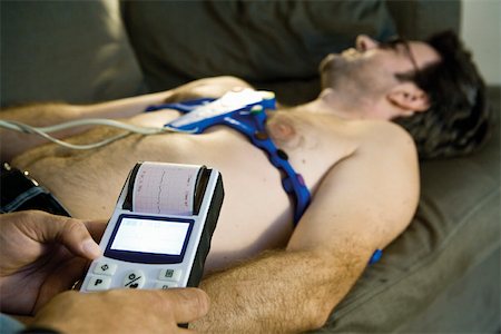 Doctor performing portable EKG (electrocardiogram) on patient in home Stock Photo - Premium Royalty-Free, Code: 632-03629698
