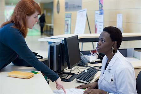 simsearch:632-03629860,k - Upset patient explaining problem to medical receptionist Stock Photo - Premium Royalty-Free, Code: 632-03629861