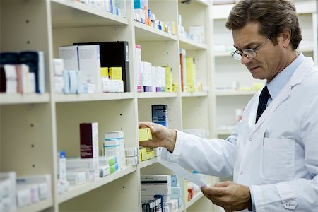decision - Pharmacist checking shelf for medication Foto de stock - Sin royalties Premium, Código: 632-03630025