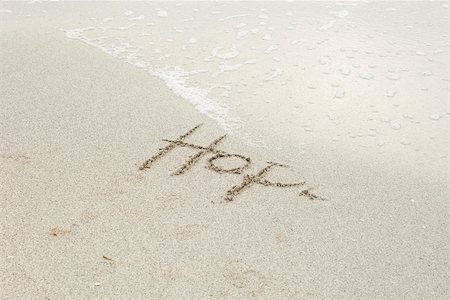 The word "hope" written in the sand at the beach, partially washed away by the tide Stock Photo - Premium Royalty-Free, Code: 632-03630261