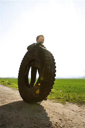 rolling - Boy rolling big tire Stock Photo - Premium Royalty-Free, Code: 632-03651666