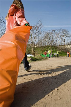 Ramasser la litière bord de la route, en faisant glisser le sac à ordures complet Photographie de stock - Premium Libres de Droits, Code: 632-03651662