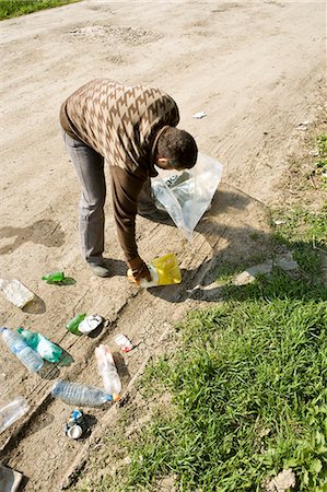 Picking up trash alongside dirt road Stock Photo - Premium Royalty-Free, Code: 632-03651680