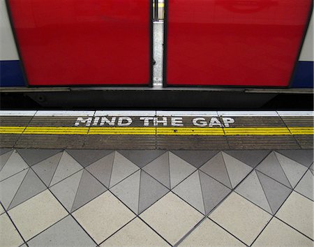 simsearch:632-03754544,k - Mind the gap warning painted on the edge of the subway platform in the London Underground Foto de stock - Sin royalties Premium, Código: 632-03651723