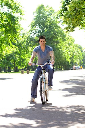 simsearch:633-03444679,k - Young man riding bicycle Foto de stock - Sin royalties Premium, Código: 632-03651755
