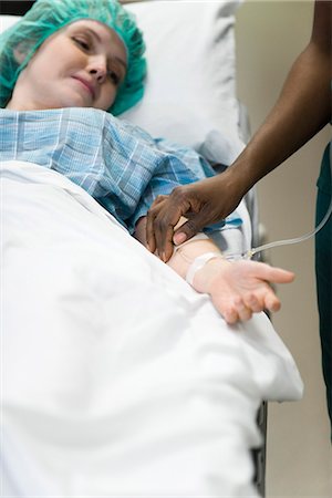 disease - Patient watching as nurse checks IV needle placement in arm Stock Photo - Premium Royalty-Free, Code: 632-03651915