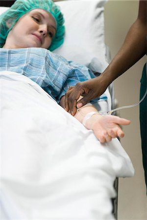 patient on iv - Patient watching as nurse checks IV needle placement in arm Stock Photo - Premium Royalty-Free, Code: 632-03651915