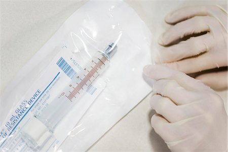 simsearch:695-03380169,k - Personnel médical ouvrir l'emballage stérile contenant une seringue médicale Photographie de stock - Premium Libres de Droits, Code: 632-03651951