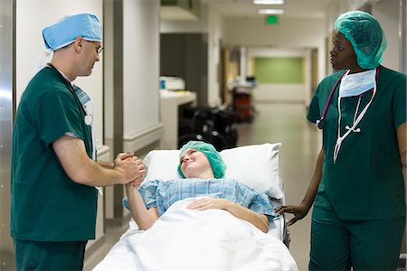 doctor scrubs patient smile - Doctor reassuring patient lying on hospital gurney Stock Photo - Premium Royalty-Free, Code: 632-03651987