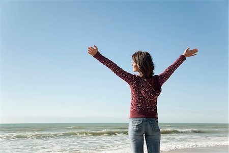 simsearch:632-03652079,k - Woman standing on beach with arms raised Fotografie stock - Premium Royalty-Free, Codice: 632-03652037