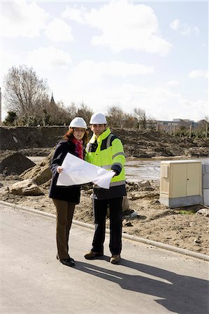 Architect and building contractor discussing blueprint at construction site Stock Photo - Premium Royalty-Free, Code: 632-03652239