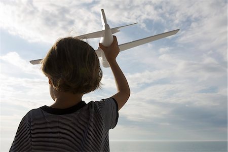 Boy playing with toy airplane, rear view Foto de stock - Sin royalties Premium, Código: 632-03652253