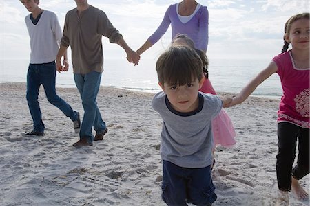 Group of people holding hands and walking on beach Stock Photo - Premium Royalty-Free, Code: 632-03652275