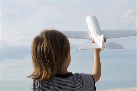 prétendre - Enfant jouant avec le jouet avion, vue arrière Photographie de stock - Premium Libres de Droits, Code: 632-03652276