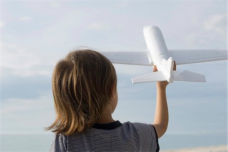 ficción - Child playing with toy airplane, rear view Foto de stock - Sin royalties Premium, Código: 632-03652276