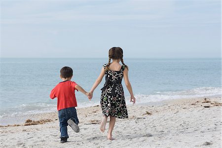 sister and brother running on beach in summer - Children running together at the beach, holding hands Stock Photo - Premium Royalty-Free, Code: 632-03652295