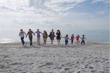 Group of people holding hands and running together on beach Stock Photo - Premium Royalty-Free, Code: 632-03652297