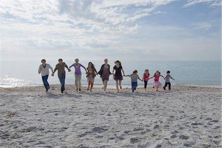 people silo group - Group of people holding hands and running together on beach Stock Photo - Premium Royalty-Free, Code: 632-03652297